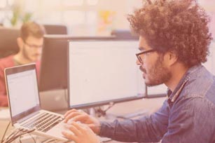 Mann arbeitet am PC im Büro