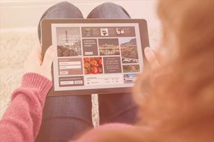 Studentin hat Tablet auf dem Schoß und betrachtet etwas darauf 