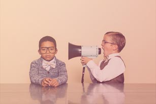 Kleiner Junge ruft einem anderen Jungen etwas durch ein Megafon zu