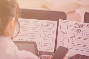 Mediendesignerin blickt auf Notizblätter, die im Laptop klemmen